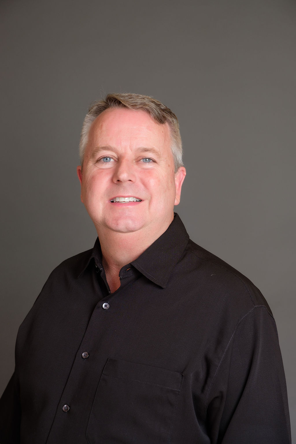 relaxed business headshot enviornmental portrait grey backdrop