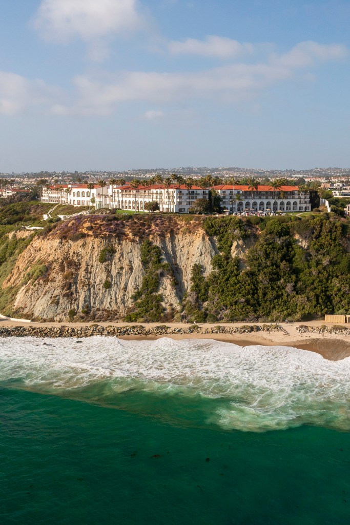 Aerial view of the Ritz Carlton hotel on a cliff overlooking the ocean in Laguna Niguel, CA, with waves crashing on the shore. corporate business event photographe nicole cadlwell